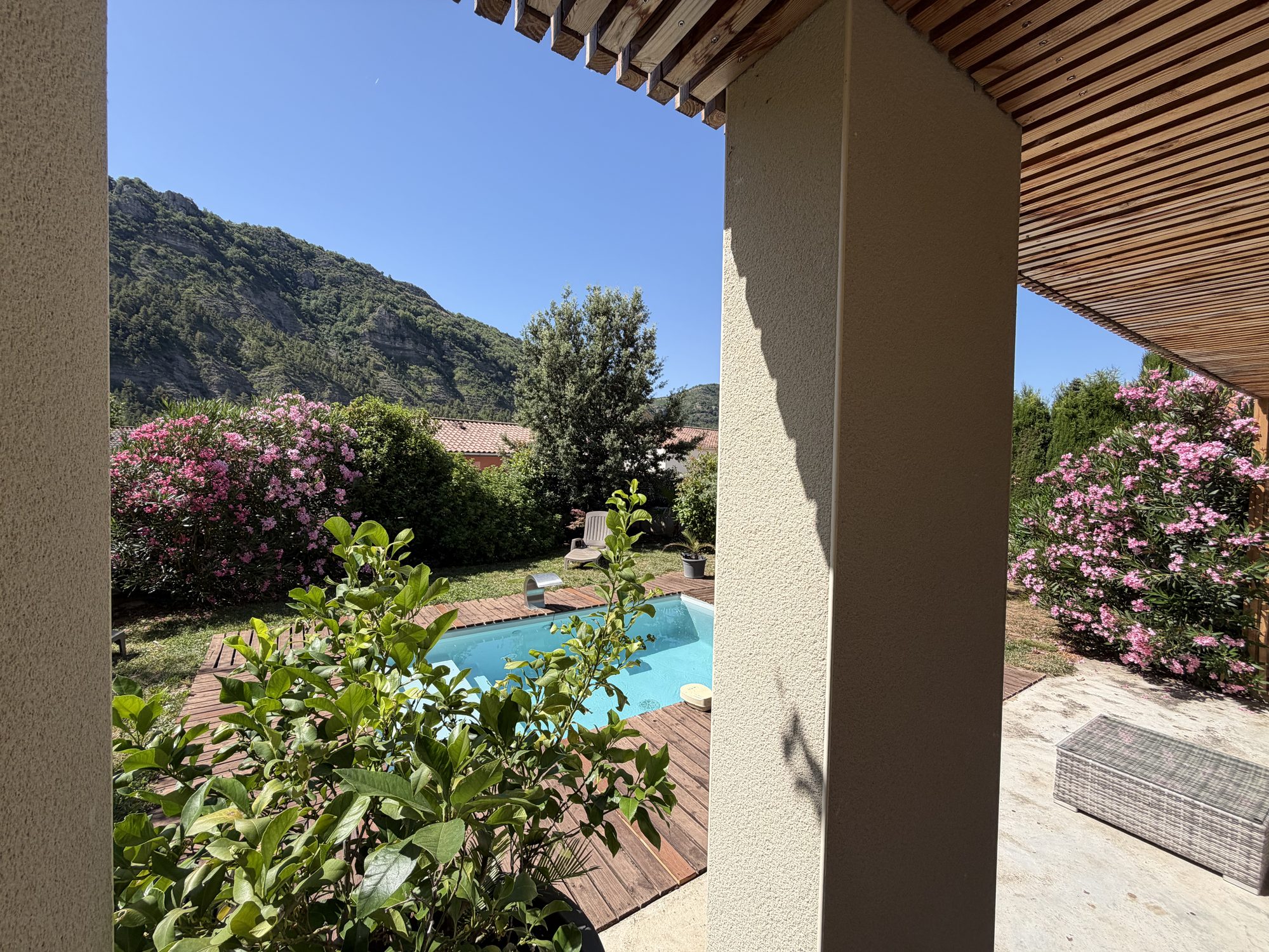 Terrasse couverte donnant sur la piscine et les falaises